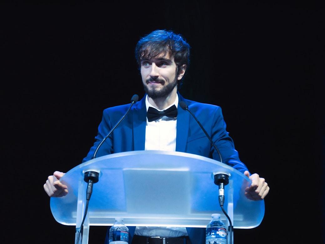 A man in a tuxedo standing at a podium